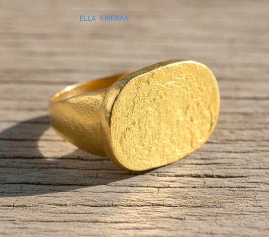 Hammered 24k 9999 Gold ring thick signet Ancient Egypt style and Ancient Rome style and with forged textured gold on a light old wooden surface, artist-jeweler's name 'Ella Kripaka' branding