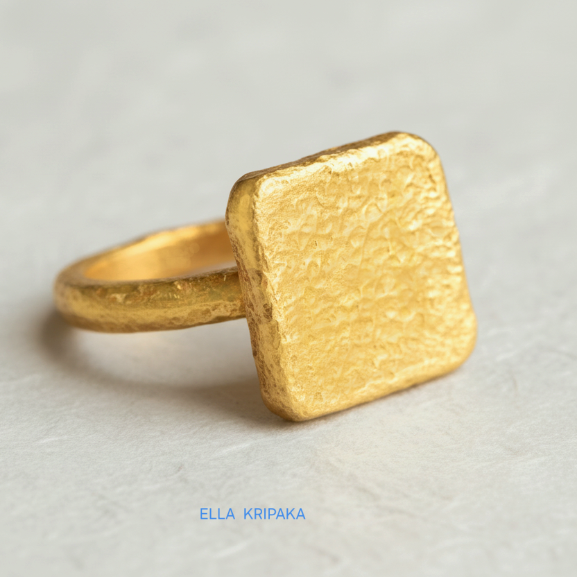 Hammered 24k 9999 Gold thick ring square signet Ancient Rome style with a textured forged gold surface on a white craft paper background, branded 'Ella Kripaka'