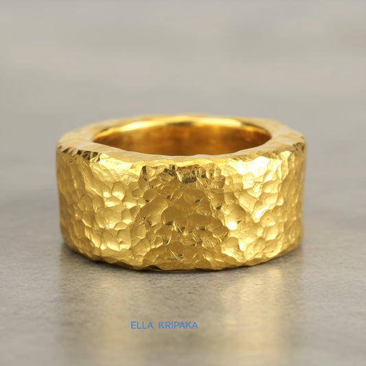 Hammered 24k 9999 Gold thick ring Ancient Rome style with textured gold on a grey concrete background, branded 'Ella Kripaka'
