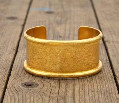 Hammered 24k 9999 gold bracelet cuff Ancient Rome style on old wooden surface with 'Ella Kripaka' branding
