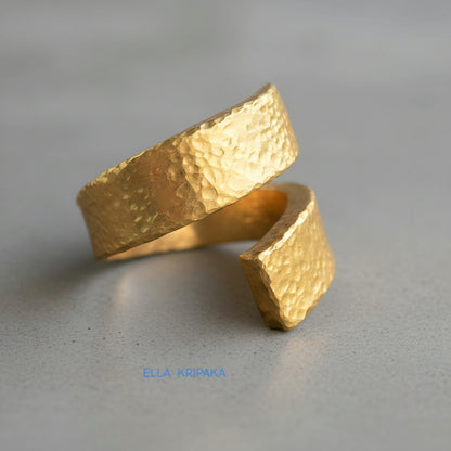 Hammered twisted 24k Gold 9999 gold signet thick ring with textured gold on a grey concrete background, branded 'Ella Kripaka'