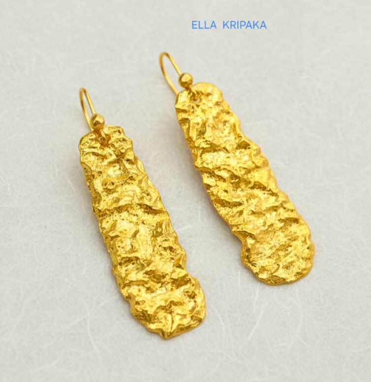 Organic hammered uneven 24k 9999 Gold earrings on a light grey surface, and with 'ELLA KRIPAKA' branding