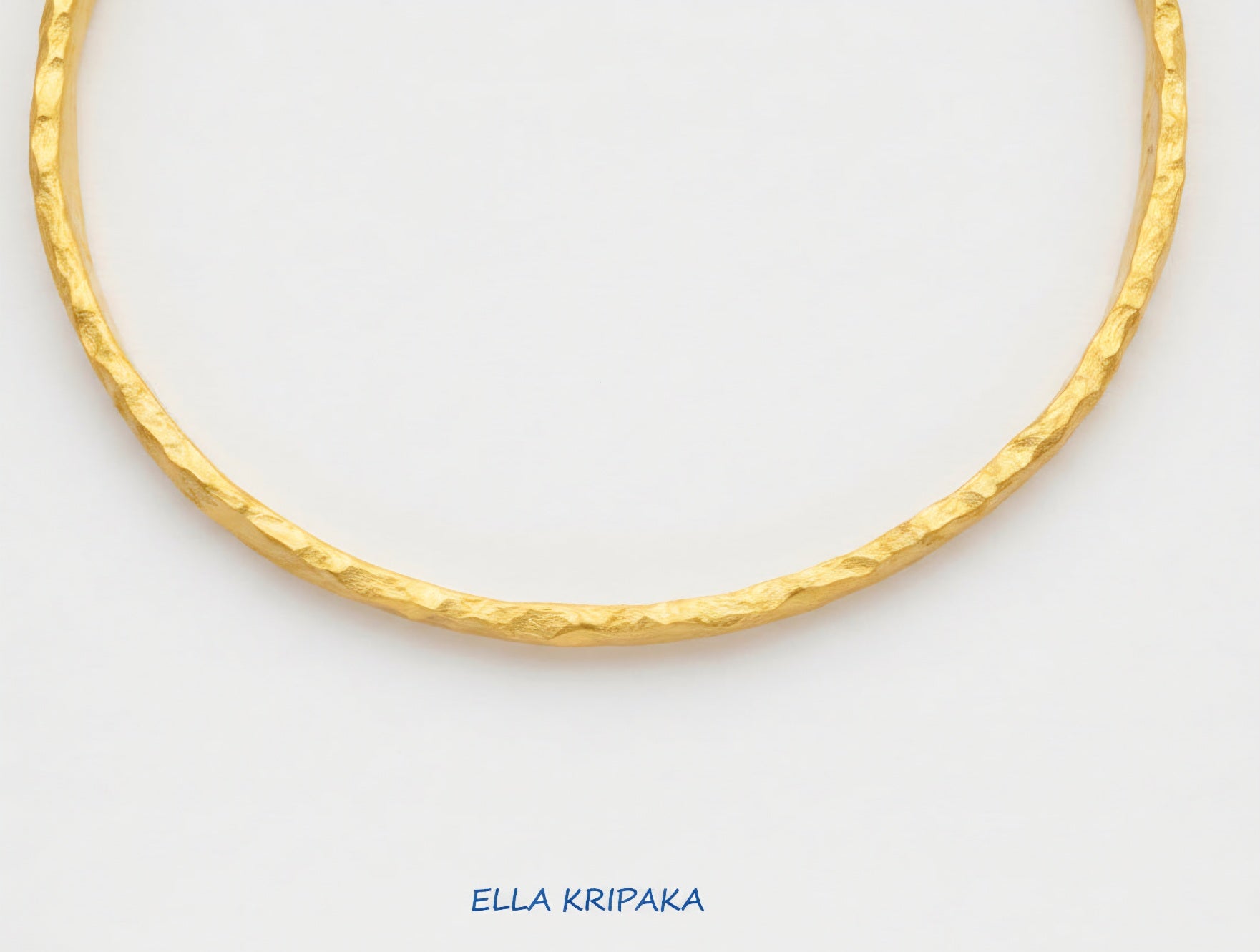 Organic hammered 24k 9999 Gold thick bangle uneven bracelet on a white background, artist's name 'Ella Kripaka' branding