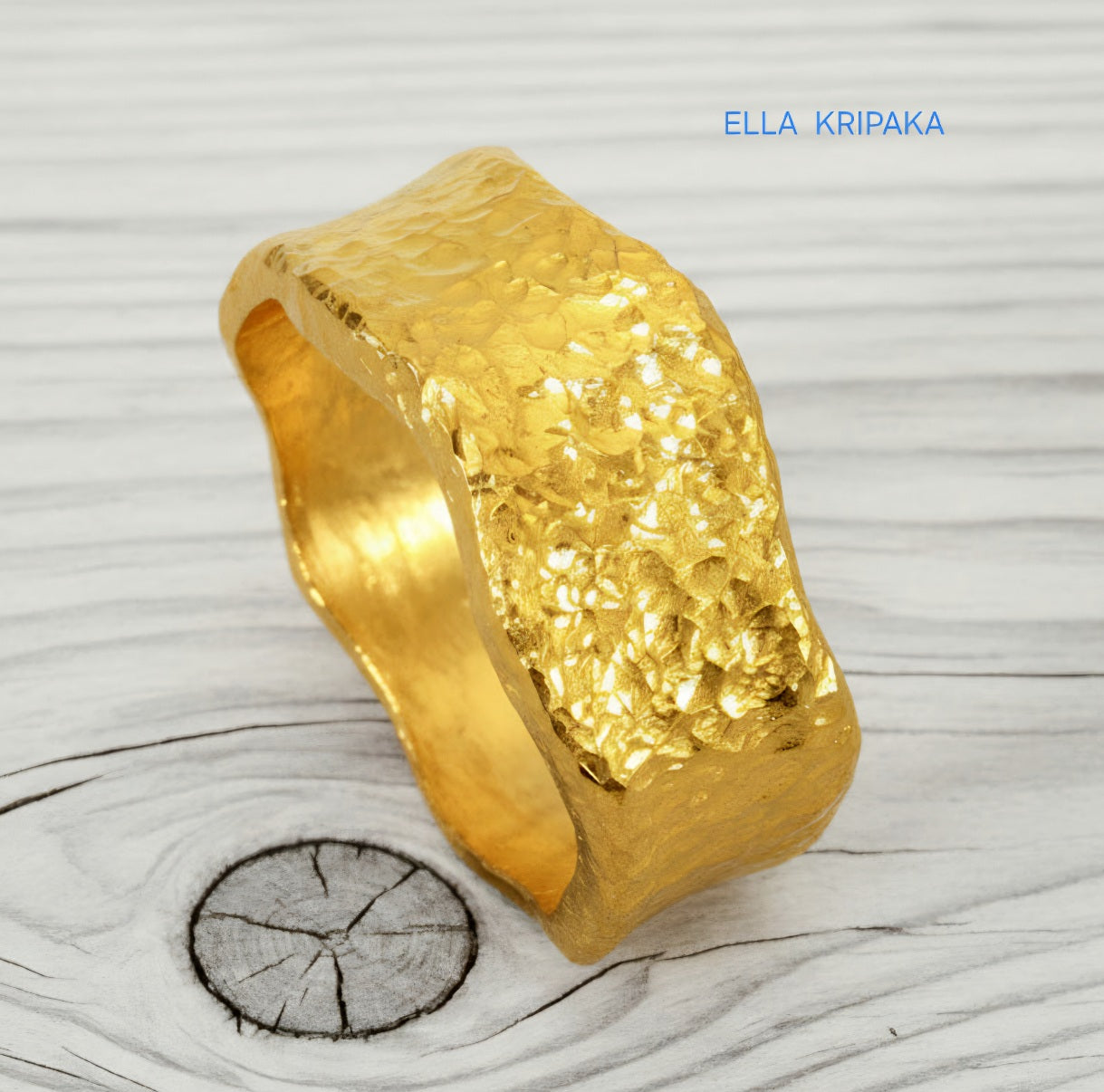 Hammered organic 24k Gold 9999 gold uneven wavy thick ring band with textured gold on a white old wooden background, branded 'Ella Kripaka'