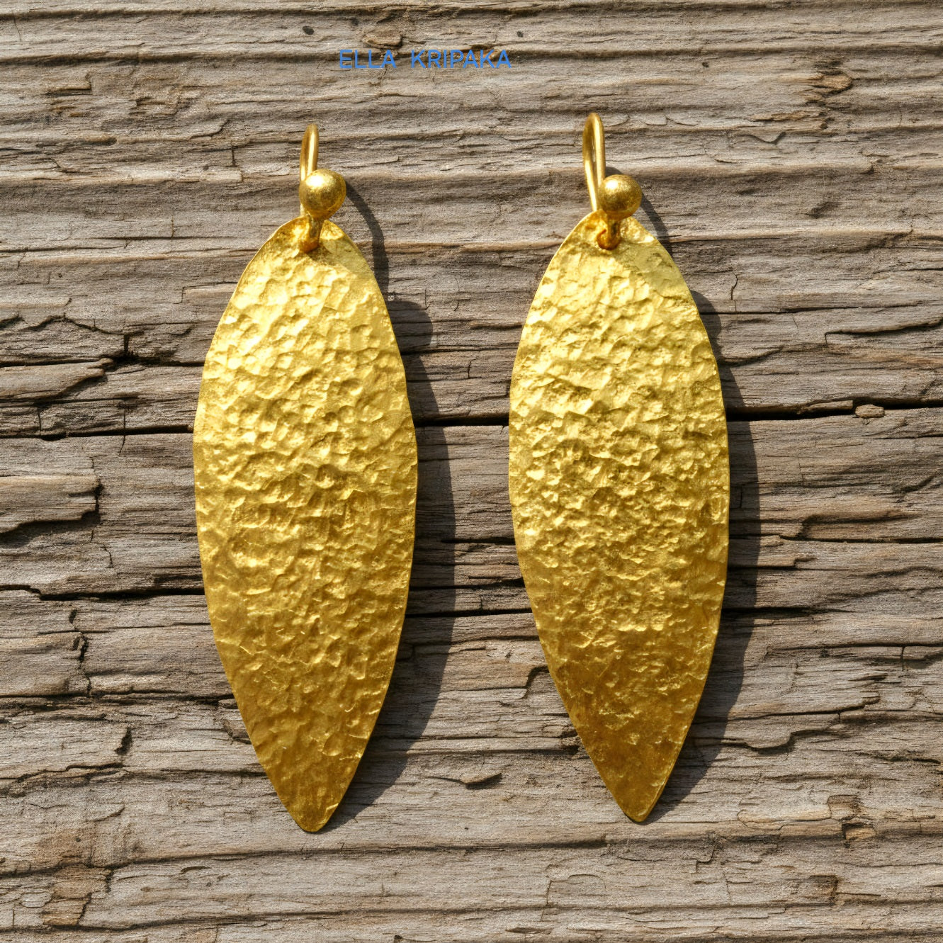 Hammered 24k 9999 Gold Byzantine leaf earrings on a old wooden background with 'Ella Kripaka' branding