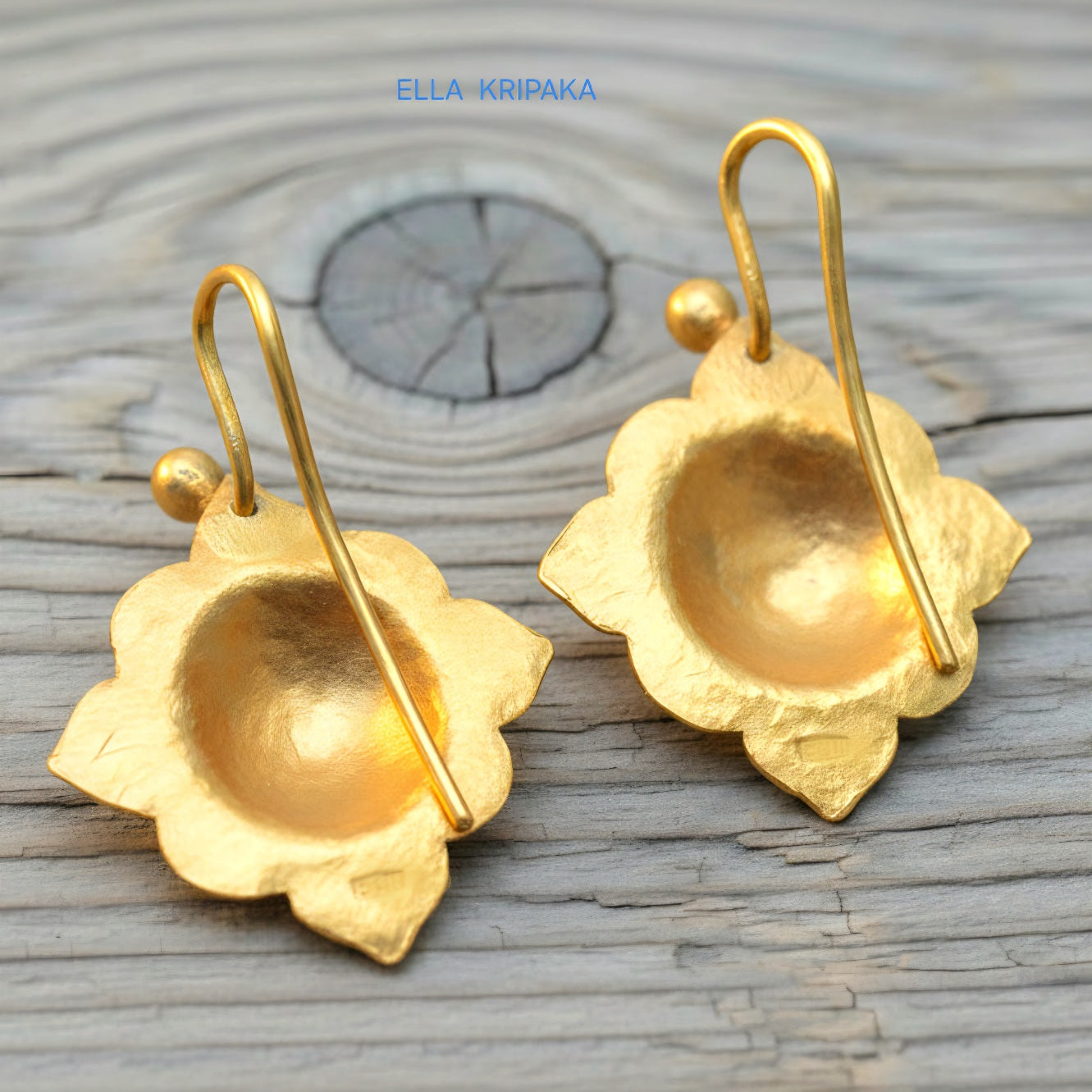 24k 9999 gold hammered Byzantine baroque convex earrings with shiny gold textures are on old wooden background, artist-jeweler's name 'Ella Kripaka'