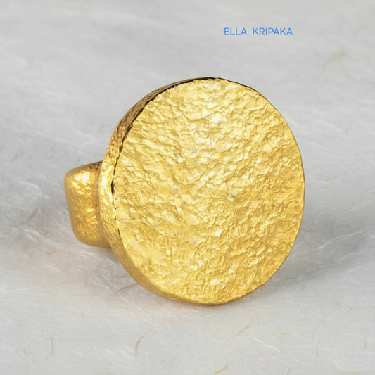Hammered 24k 9999 Gold thick ring disk signet Ancient Rome style and Byzantine style with a textured gold on a white craft paper background, branded 'Ella Kripaka'