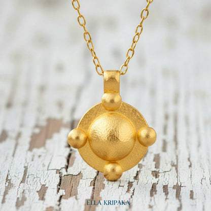 24k gold hammered dome disk with convex rounds textured pendant with chain on white old wooden background, artist 'Ella Kripaka' branding