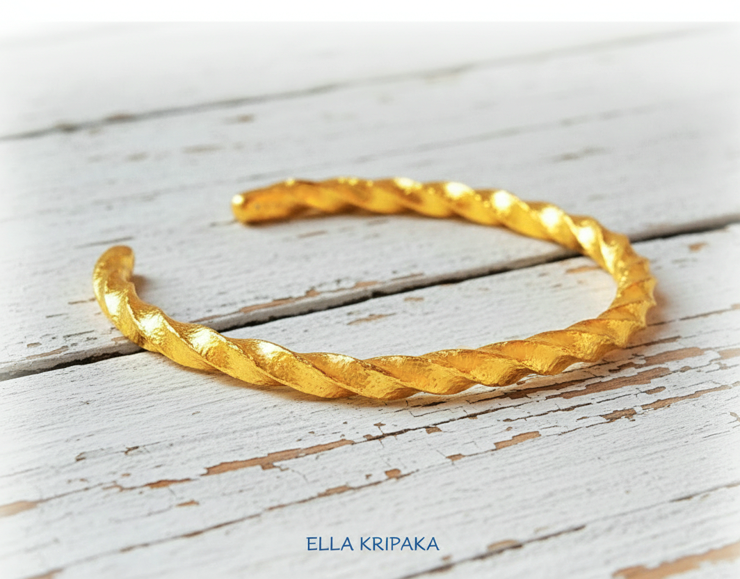 Viking twisted hammered 24k 9999 Gold thick cuff bracelet on a old wooden background, and with 'Ella Kripaka' branding