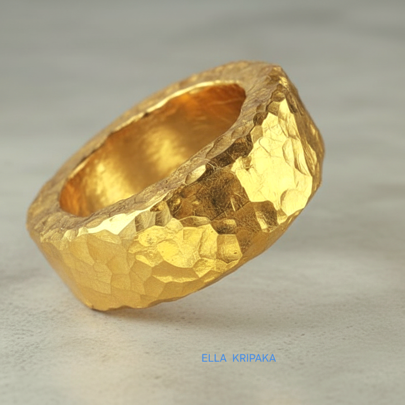 Hammered 24k 9999 Gold thick uneven ring organic with a textured gold surface on a grey concrete background, branded 'Ella Kripaka'