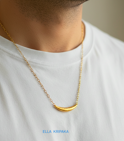 Hammered 24k gold convex Moon pendant with chain worn by a man and with a white blurred background with 'Ella Kripaka' branding