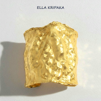 Hammered 24k gold large cuff bracelet with convex uneven textures on a white paper background, and with 'Ella Kripaka' branding