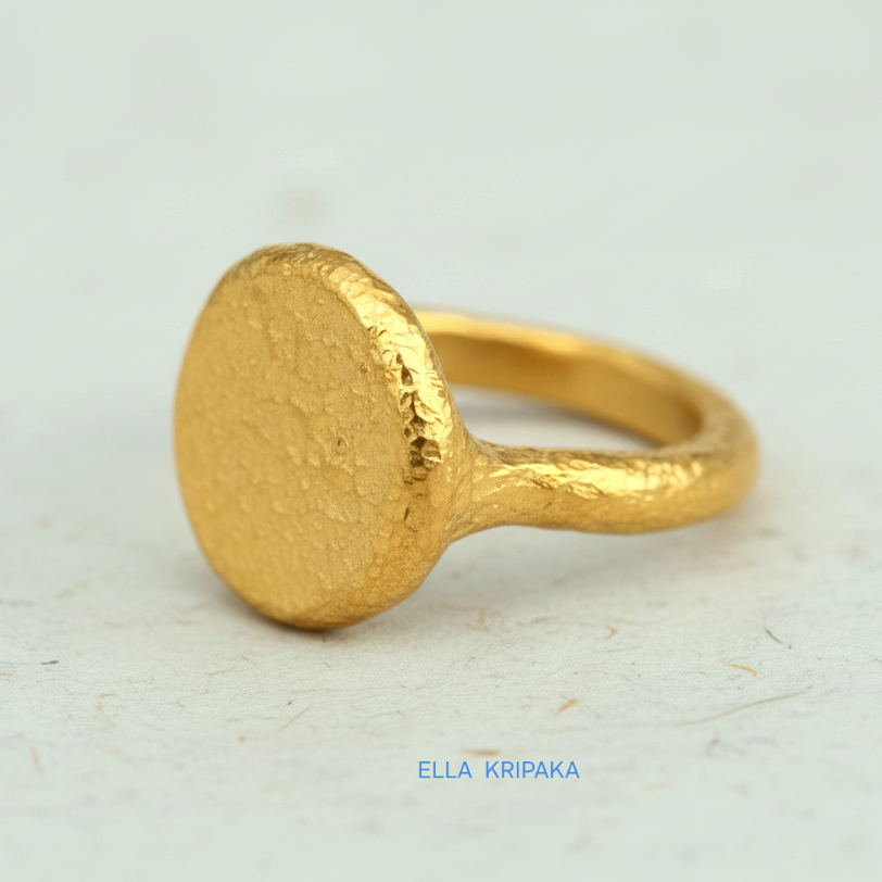 Hammered 24k 9999 Gold thick ring disk signet Ancient Rome style with a textured forged gold surface on a white craft paper background, branded 'Ella Kripaka'