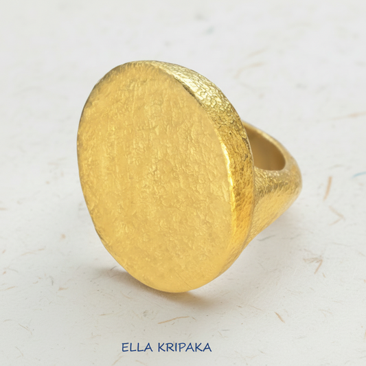 Hammered 24k 9999 Gold thick ring disk signet Ancient Rome style and Byzantine style with a textured gold on a white craft paper background, branded 'Ella Kripaka'