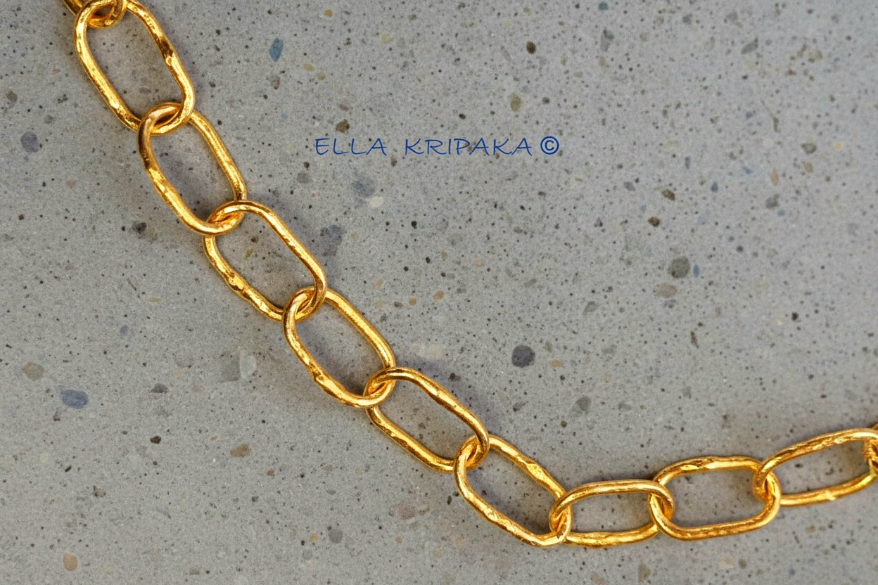 22k gold hammered chain on grey concrete background, artist-jeweler's name 'Ella Kripaka' branding