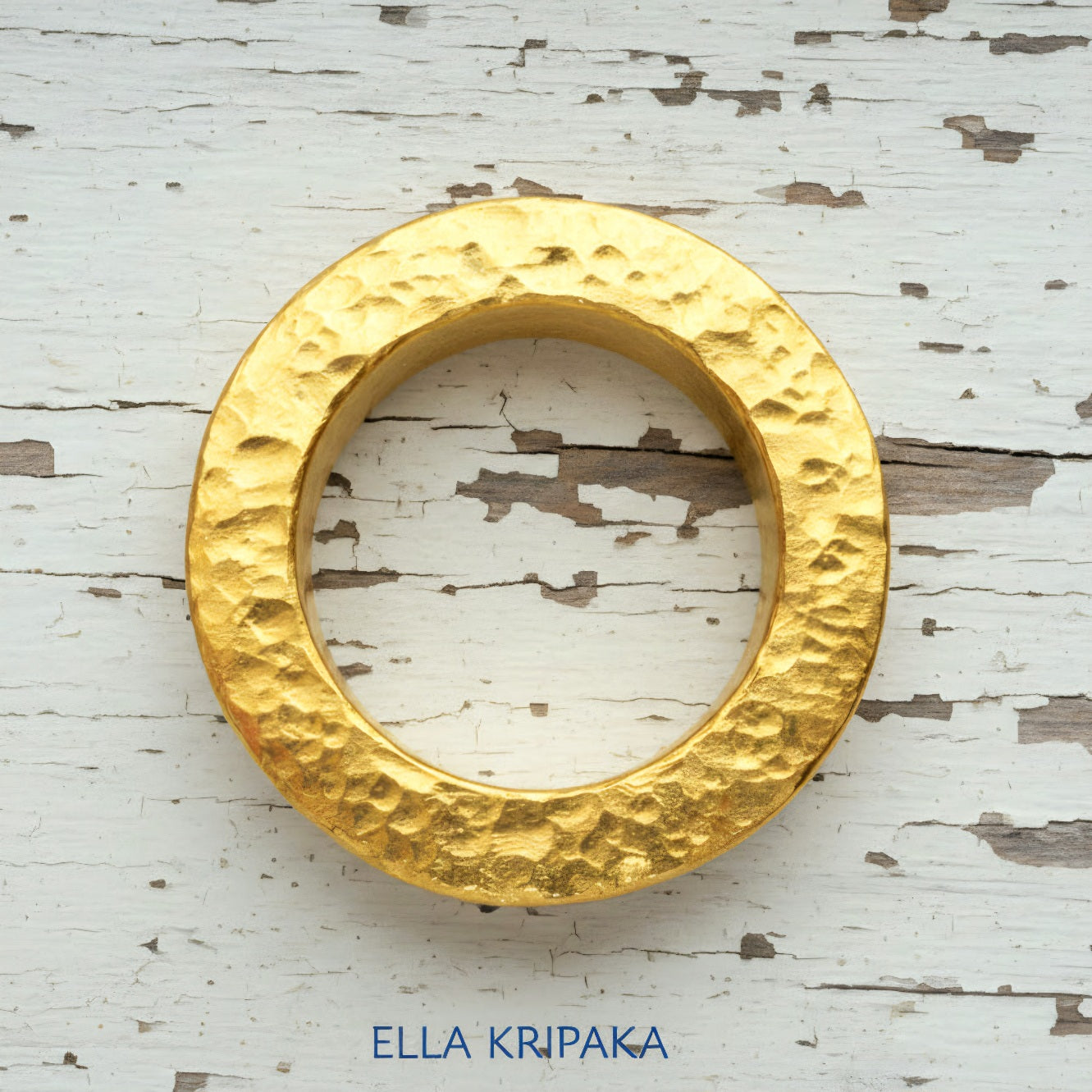 Hammered 24k 9999 Gold thick ring Ancient Rome style on old white wooden surface, artist-jeweler's name 'Ella Kripaka' branding