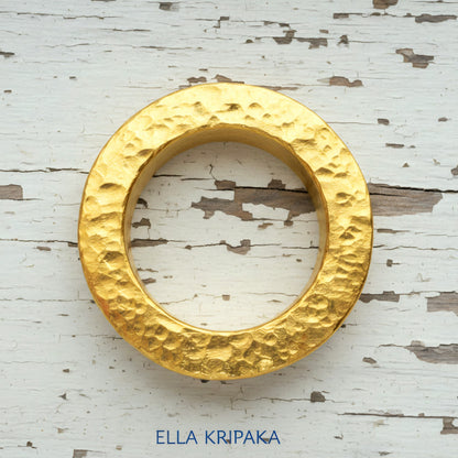 Hammered 24k 9999 Gold thick ring Ancient Rome style on old white wooden surface, artist-jeweler's name 'Ella Kripaka' branding