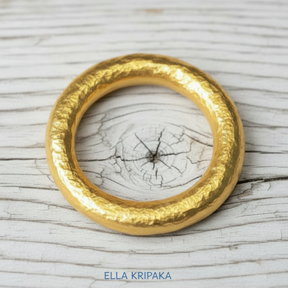 Hammered 24k 9999 Gold ring thick Ancient Rome style on old white wooden surface, artist-jeweler's name 'Ella Kripaka' branding