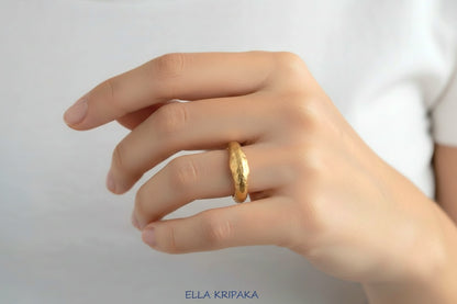 Organic hammered 24k 9999 Gold ring signet with uneven thick edges worn on person's finger and on a white background, artist-jeweler's name 'Ella Kripaka' is written in picture