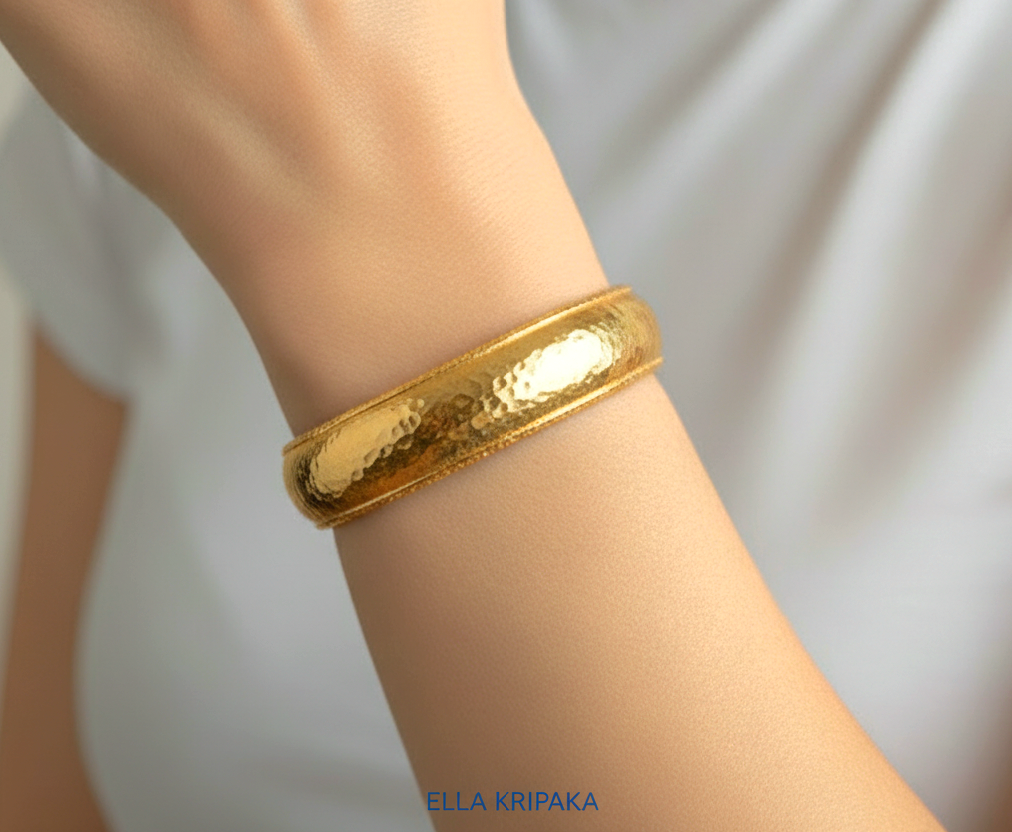 24k 9999 gold hammered Ancient Rome convex  cuff bracelet worn on a wrist by a person and on a neutral background, branded 'Ella Kripaka'