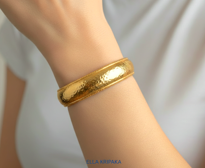 24k 9999 gold hammered Ancient Rome convex  cuff bracelet worn on a wrist by a person and on a neutral background, branded 'Ella Kripaka'