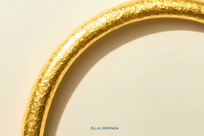 24k 9999 gold hammered Ancient Rome thick cuff bracelet on a grey old wooden surface, branded 'Ella Kripaka'