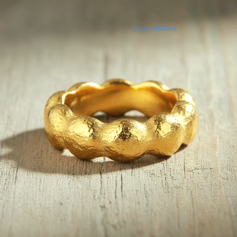 Organic hammered 24k 9999 Gold ring with wavy thick edges on grey old wooden surface, artist-jeweler's name 'Ella Kripaka' is written in picture