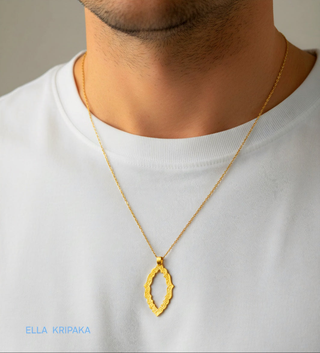 Hammered 24k gold Byzantine ornament pendant with chain worn by a person and with a white blurred background with 'Ella Kripaka' branding