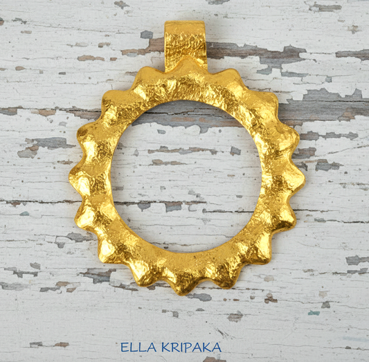 24k 9999 gold hammered convex Sun pendant on a white old wooden surface, branded 'Ella Kripaka'