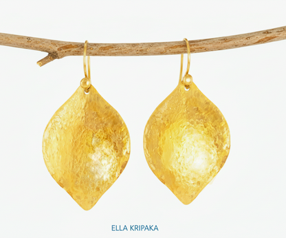 Hammered 24k 9999 Gold convex leaf earrings Ancient Rome and Byzantine style hanging on thin branch on a white background, and artist-jeweler's name 'Ella Kripaka' branding