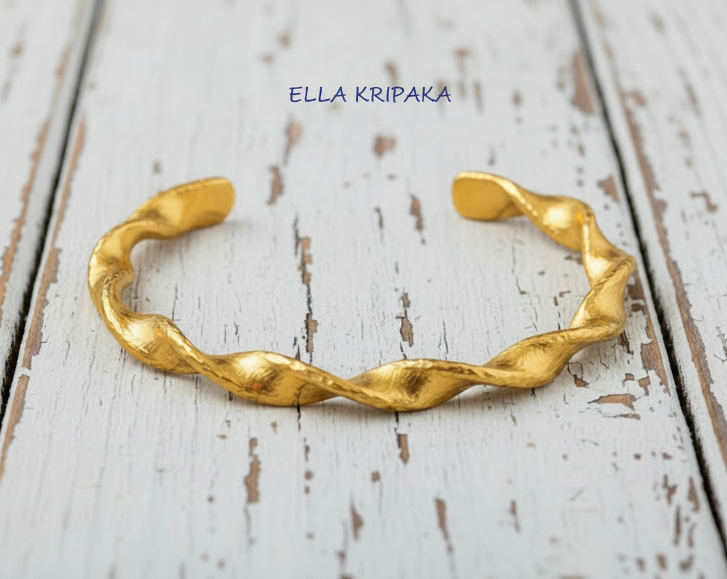 Twisted Viking hammered 24k 9999 gold bracelet cuff on a old white old wooden background, branding artist-jeweler name 'Ella Kripaka'