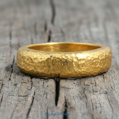 Hammered 24k Gold 9999 gold Ancient Rome  thick ring with textured forged gold on a grey old wooden background, branded 'Ella Kripaka'