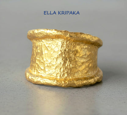 Organic hammered 24k 9999 gold ring signet with uneven thick edges on grey surface, artist-jeweler's name 'Ella Kripaka' is written in picture