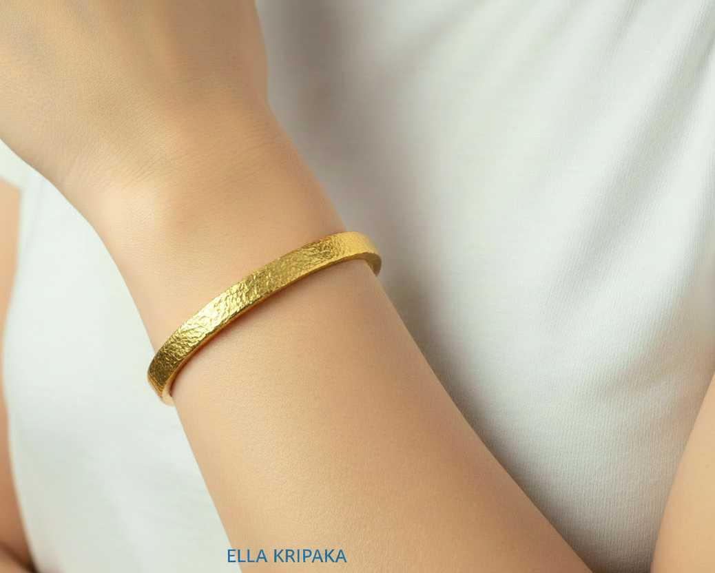 Hammered 24k 9999 gold cuff thick bracelet Ancient Rome style on person's wrist and on a white background, artist-jeweler's name 'Ella Kripaka'