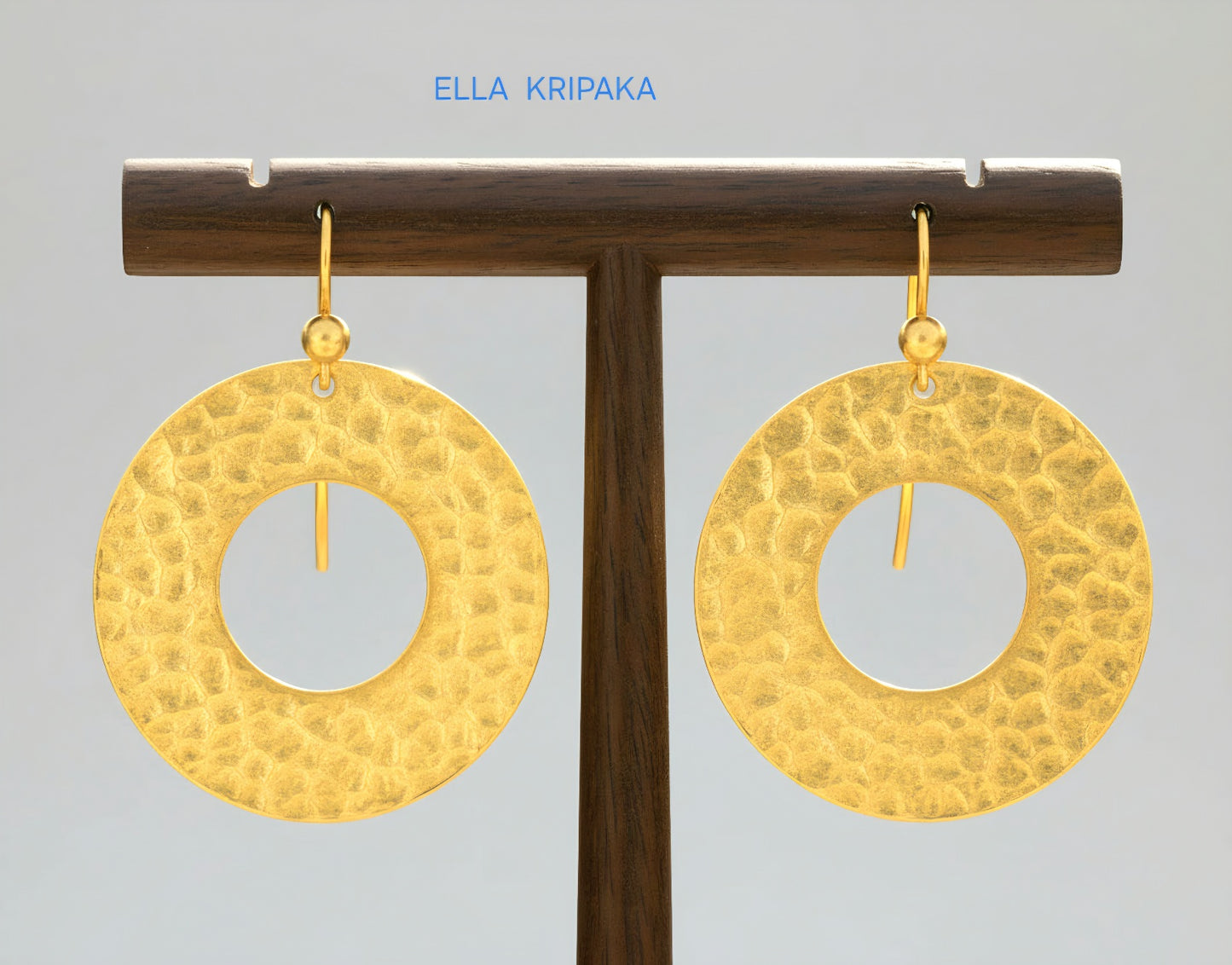 24k 9999 gold hammered hoop earrings Ancient Rome style shiny gold textures are on wooden stand and on grey background, artist-jeweler's name 'Ella Kripaka'