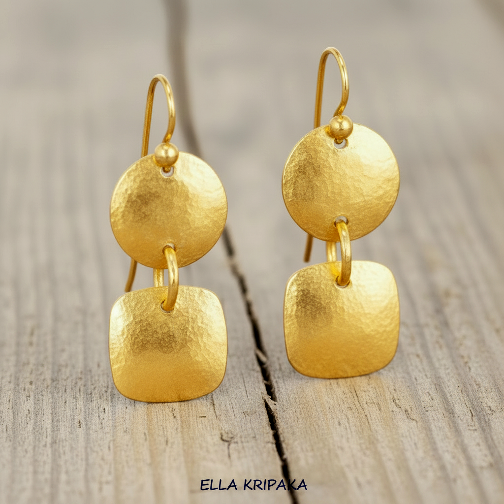 Hammered 24k gold dangling earrings with convex disks and squares are on light rustic wooden background, branding artist-jeweler 'Ella Kripaka'