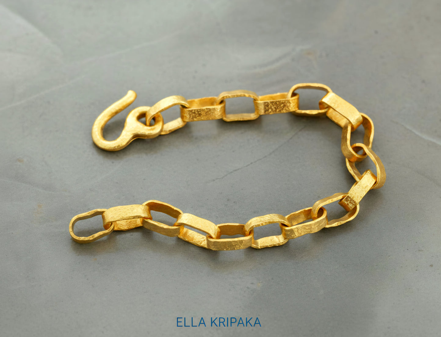 Hammered 24k 9999 gold chain thick bracelet with thick hook clasp Ancient Rome style on a grey background, artist-jeweler name 'Ella Kripaka' branding