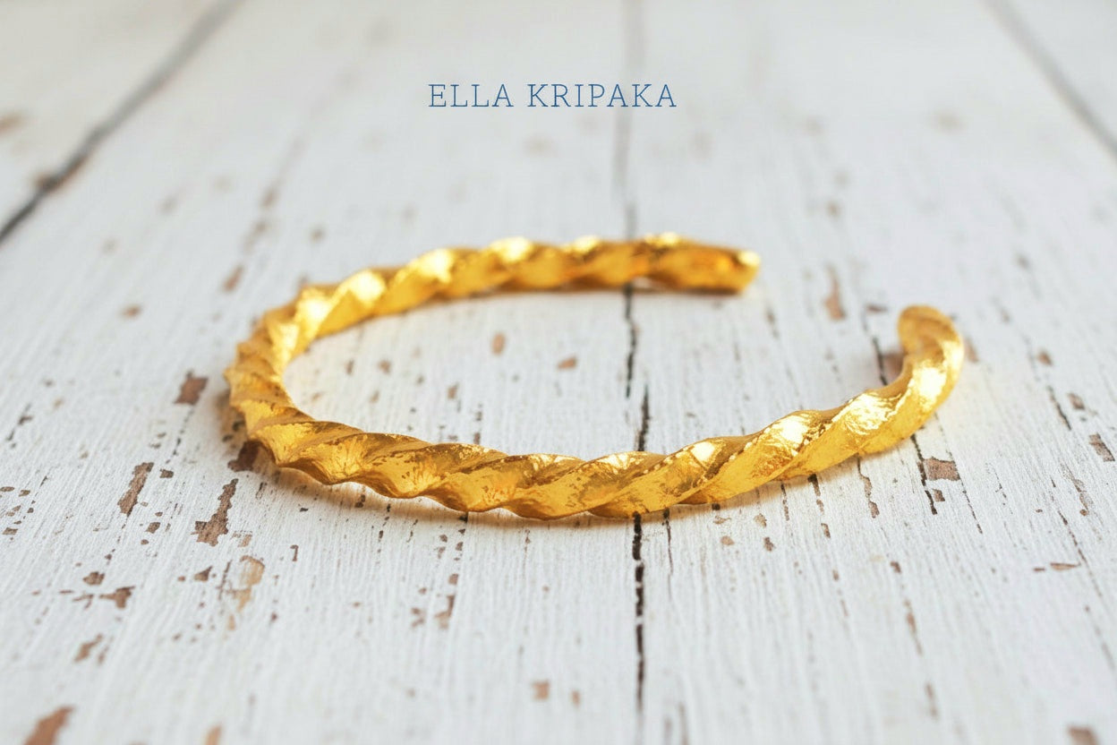 Viking twisted hammered 24k 9999 Gold thick cuff bracelet on a old wooden background, and with 'Ella Kripaka' branding