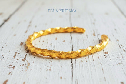 Viking twisted hammered 24k 9999 Gold thick cuff bracelet on a old wooden background, and with 'Ella Kripaka' branding