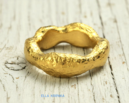 Hammered 24k 9999 Gold thick uneven wavy ring organic with textured gold on a white old wooden background, branded 'Ella Kripaka'