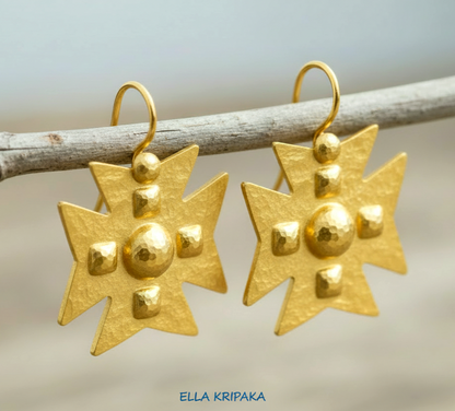 Hammered 24k 9999 Gold Byzantine cross earrings on a old wooden background with 'Ella Kripaka' branding