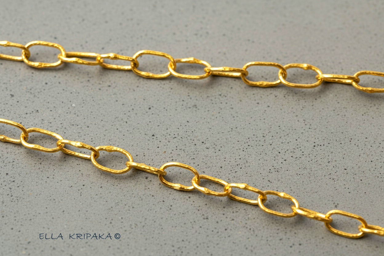 22k gold hammered chain on grey concrete background, artist-jeweler's name 'Ella Kripaka' branding