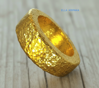 Hammered 24k 9999 Gold thick ring Ancient Rome style with a textured forged gold surface on a old wooden background, branded 'Ella Kripaka'