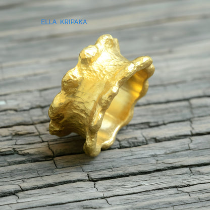 Hammered 24k 9999 Gold thick uneven wavy ring organic with a textured gold surface on a old wooden background, branded 'Ella Kripaka'
