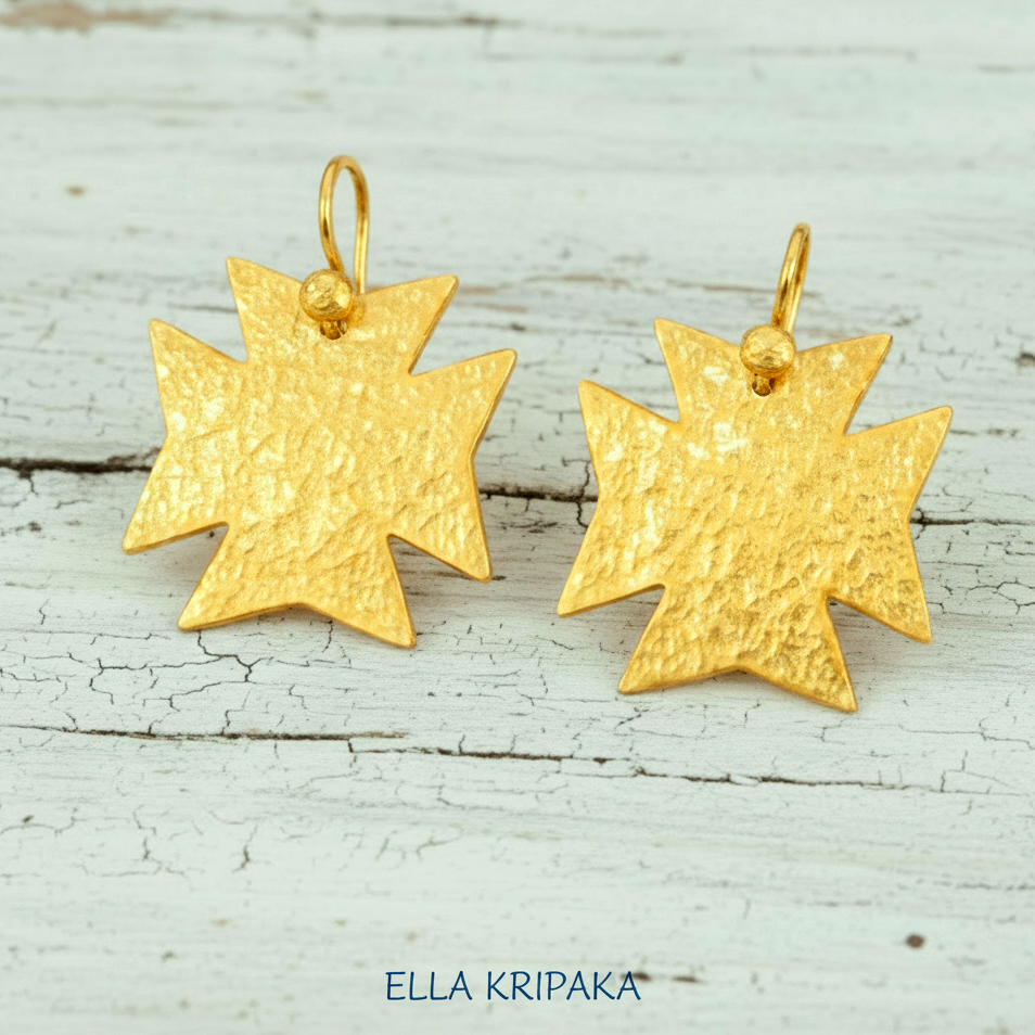 Hammered 24k gold, pure 9999 gold Byzantine cross earrings with shiny forged gold textures on white old wooden surface, artist-jeweler 'Ella Kripaka' branding