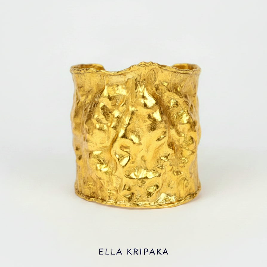 Hammered 24k gold large cuff bracelet with convex uneven textures and with 65 mm of width on a white background, and with 'Ella Kripaka' branding