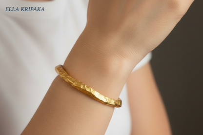 Organic hammered 24k 9999 Gold thick uneven cuff bracelet worn on woman's wrist and with white t-shirt and with 'Ella Kripaka' branding