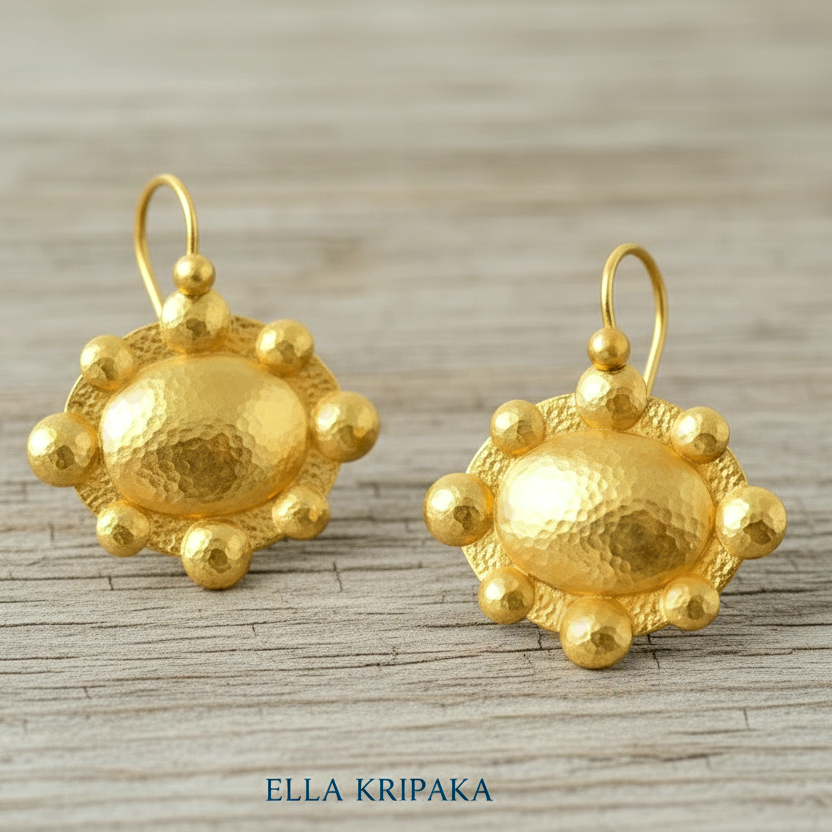 Hammered 24k 9999 Gold Byzantine convex earrings on a old grey wooden background with 'Ella Kripaka' branding