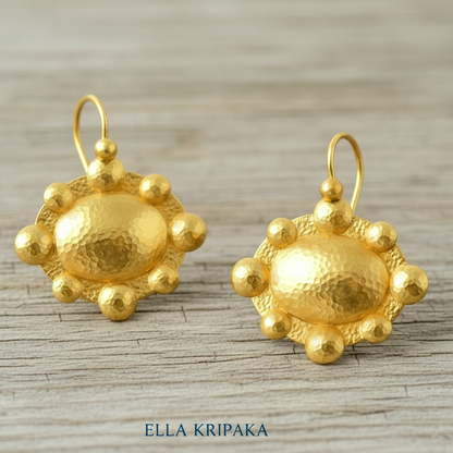 Hammered 24k 9999 Gold Byzantine convex earrings on a old grey wooden background with 'Ella Kripaka' branding