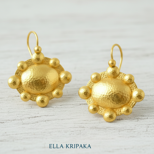 Hammered 24k 9999 Gold Byzantine convex earrings on a old grey wooden background with 'Ella Kripaka' branding